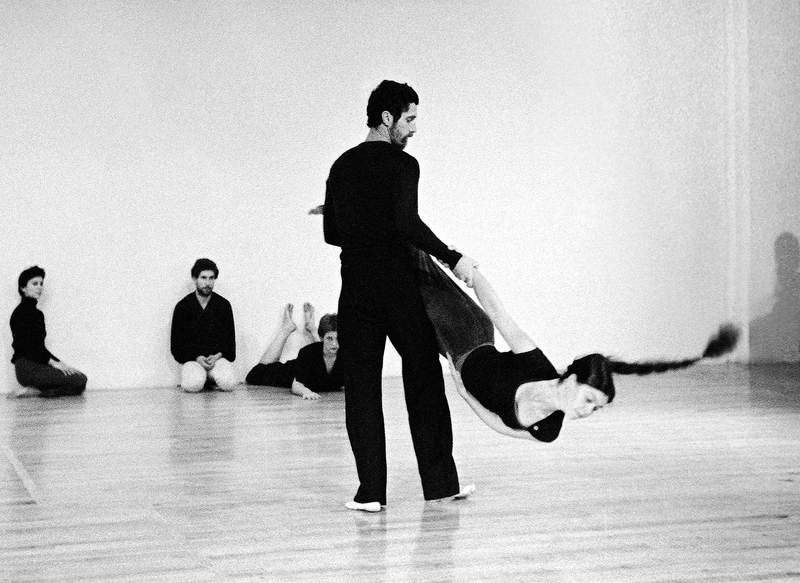 Buddha statue with beautiful light flowers in the foreground, soft focus, black and white.