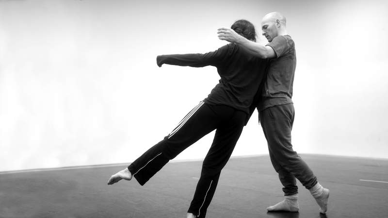 Buddha statue with beautiful light flowers in the foreground, soft focus, black and white.