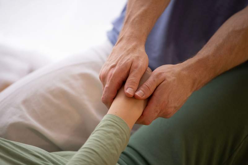 Buddha statue with beautiful light flowers in the foreground, soft focus, black and white.